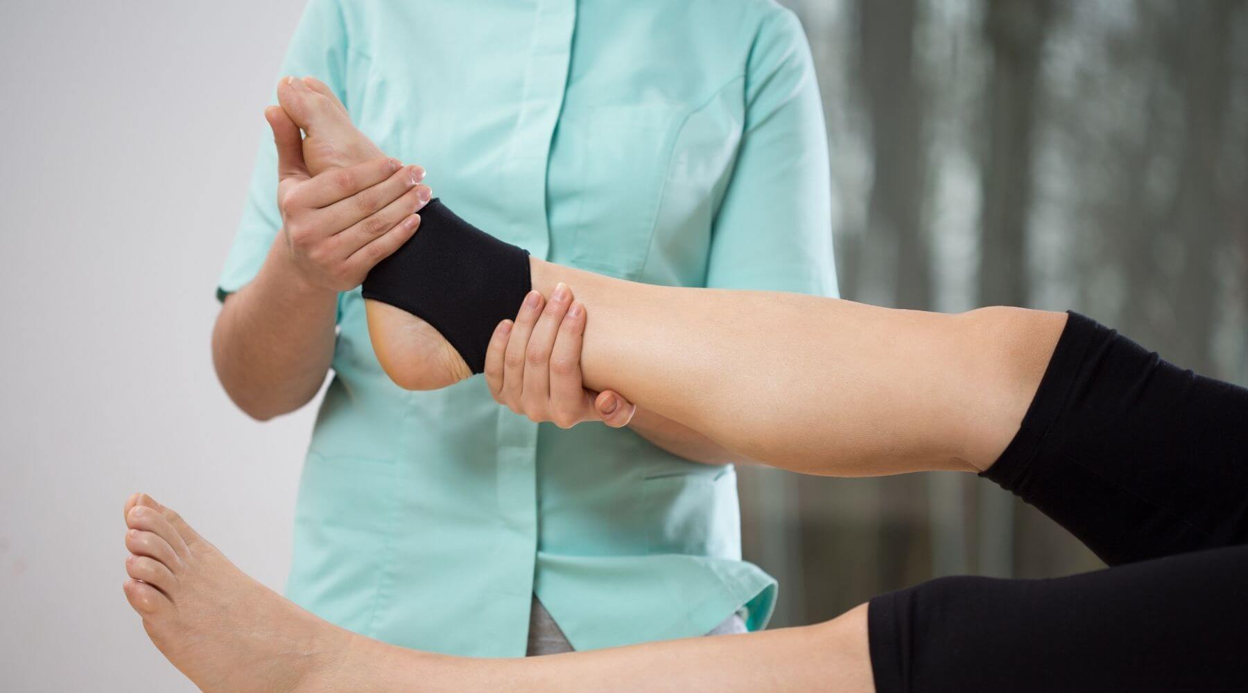 Therapist holding ankle with brace