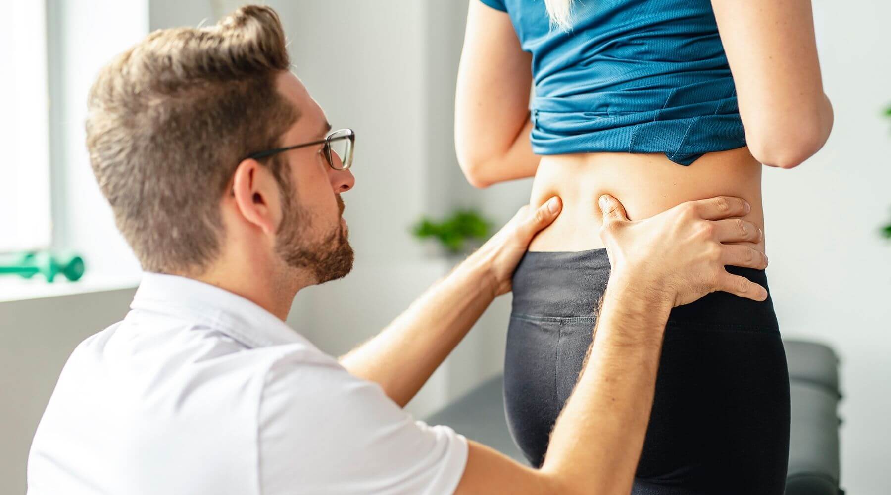 Therapist working lower back of standing patient