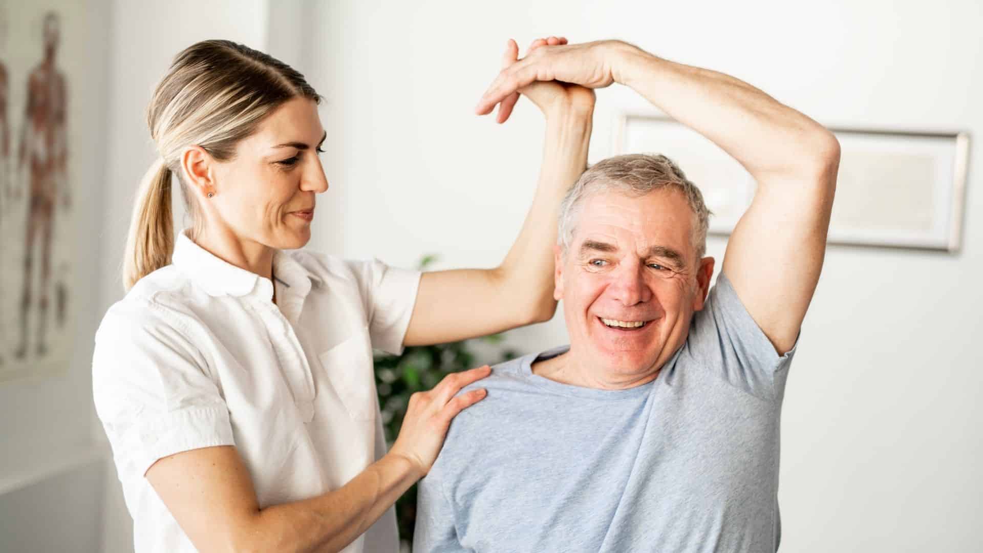 older male doing arm stretch with female PT