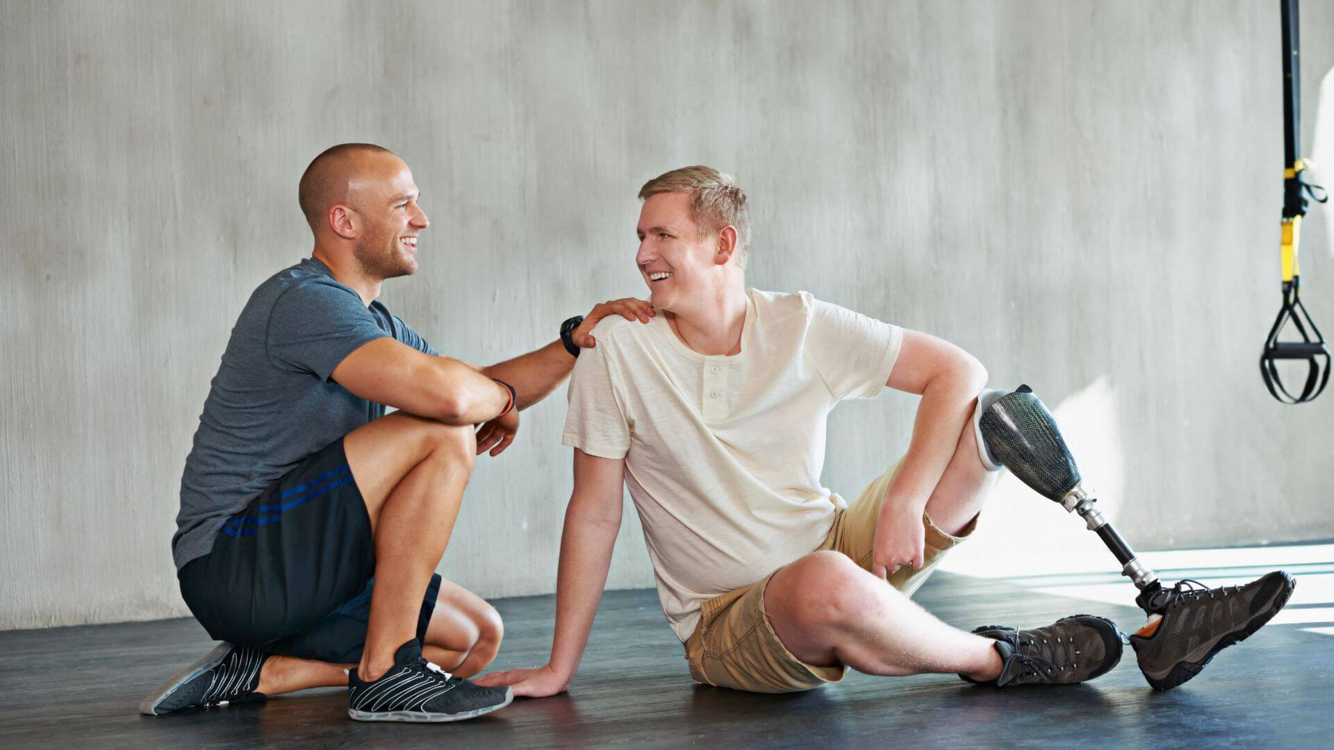 leg amputee male in therapy with trainer