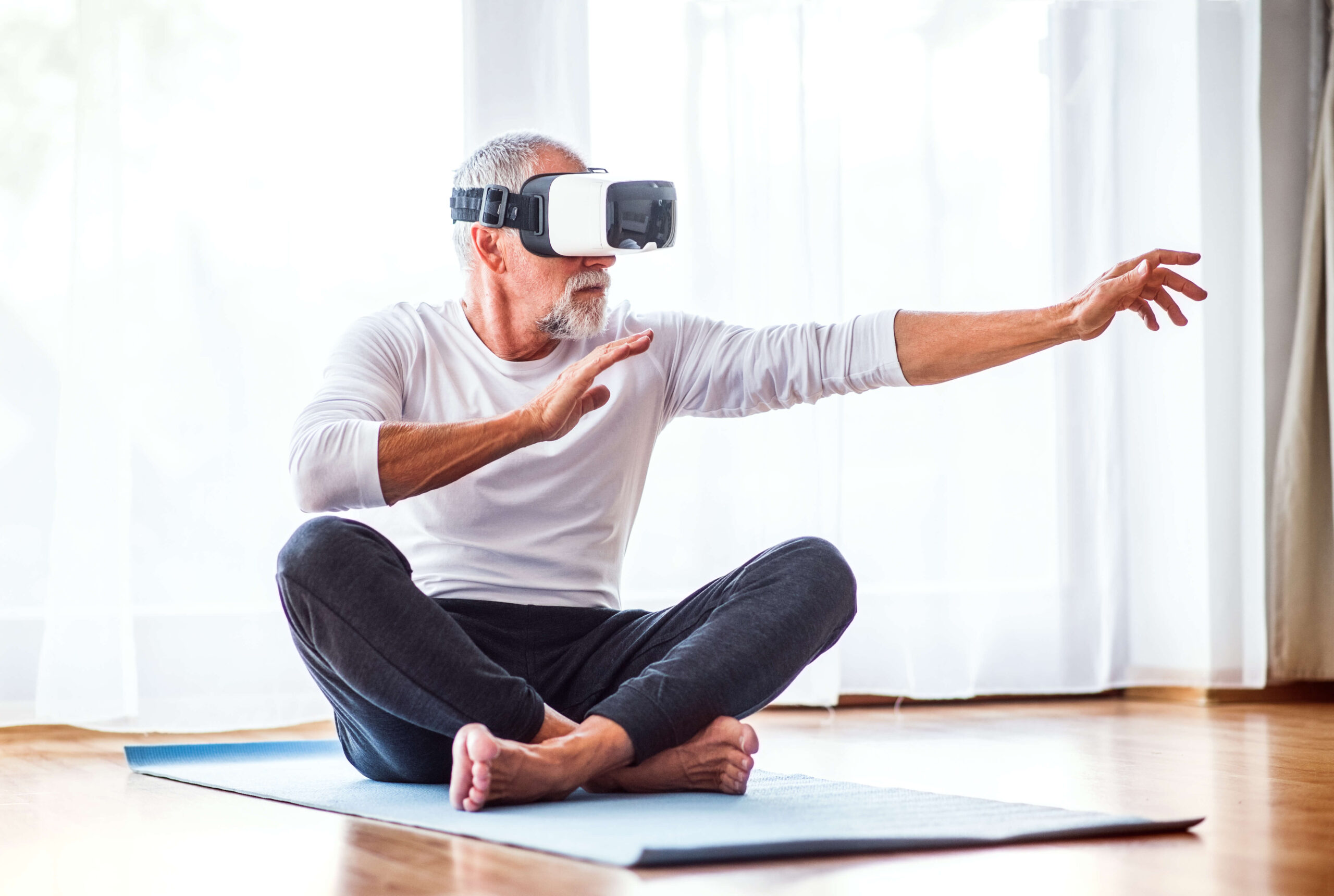 middle age man on yoga mat wearing VR headset