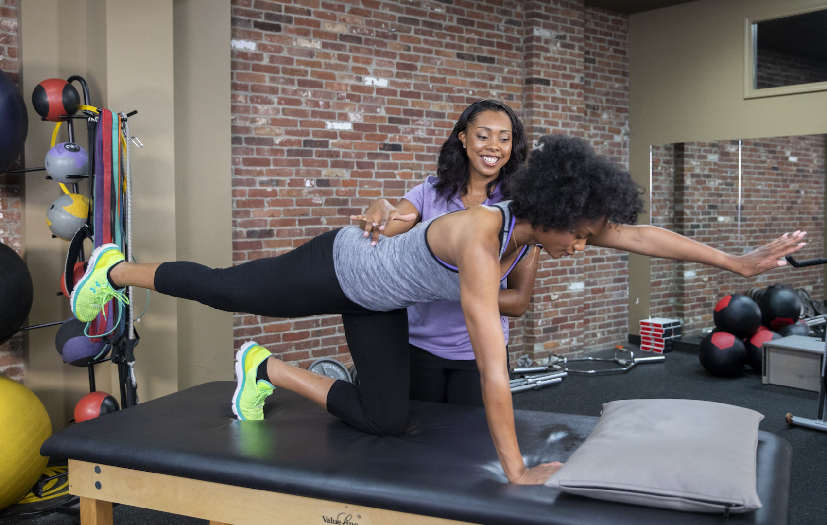 Woman posing for physical rehab with trainer