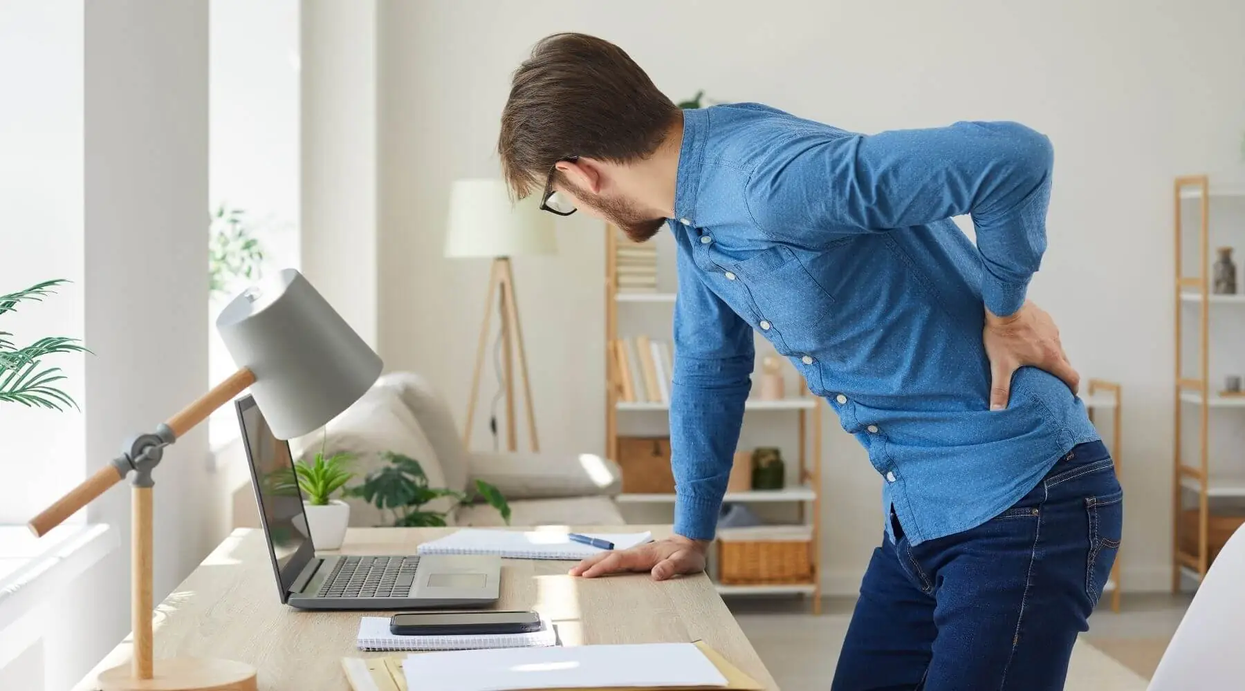 main with back pain bent over desk reverse angle