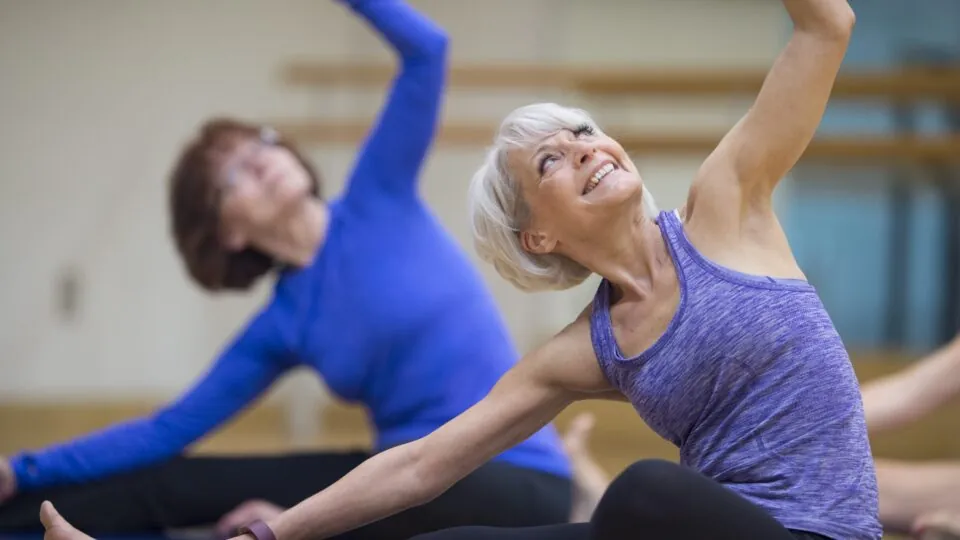 Older and younger woman doing yoga pose