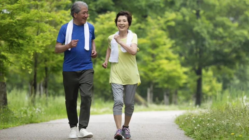 older couple speed walking in the park