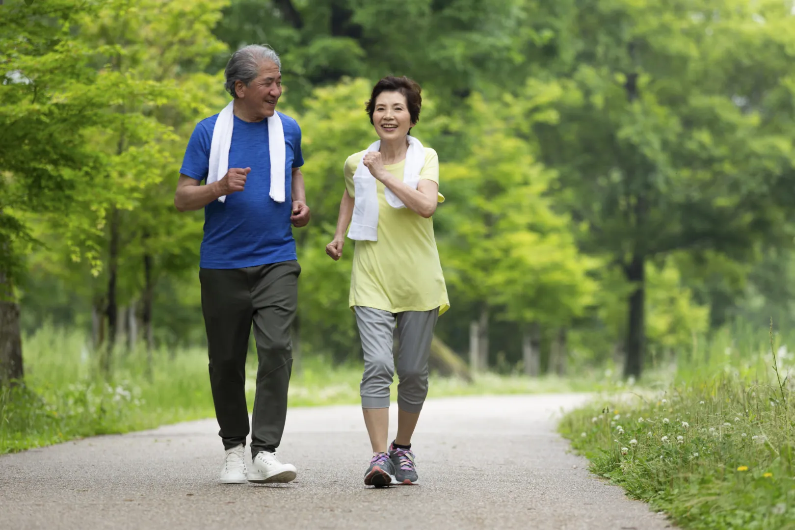 older couple speed walking in the park